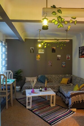 Ein gemütliches Wohnzimmer mit einer Couch, einem Couchtisch und einem gemusterten Teppich.