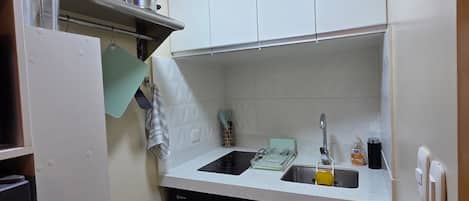 A compact kitchen with a dishwasher, a sink, and a stove.