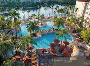 A resort with a central pool surrounded by palm trees and sun loungers. - King Villa Resort with Balcony near Orlando’s I-Drive (Orlando)