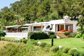 A modern house with a patio, outdoor seating, and a view of the surrounding forest. - Villa Jondal (Jesús)