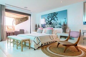 A modern bedroom with a bed, bedside tables, a chair, and a large window. - Villa Jondal (Jesús)