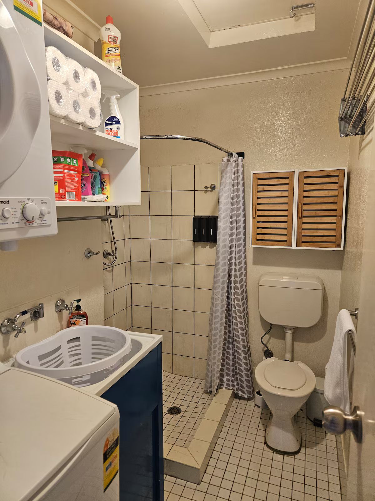 A compact bathroom with a shower, toilet, and a sink.