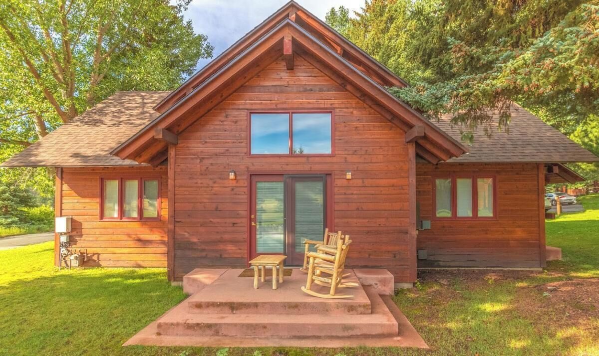 Eine Holzhütte mit einer Veranda, zwei Fenstern und einer Tür.