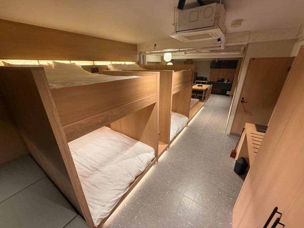 A room with bunk beds, a kitchenette, and a small dining area.