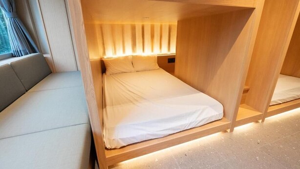 A single bed with a wooden frame and a headboard with vertical slats. - Villa Customa (Taito City)