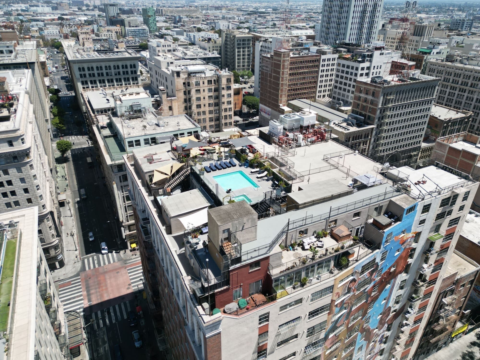 Ein Hochhaus mit mehreren Stockwerken, einem Dachpool und der umliegenden Stadtlandschaft.