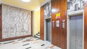 Eine Lobby mit einer großen Karten-Wandmalerei, einem Aufzug und einer Treppe.