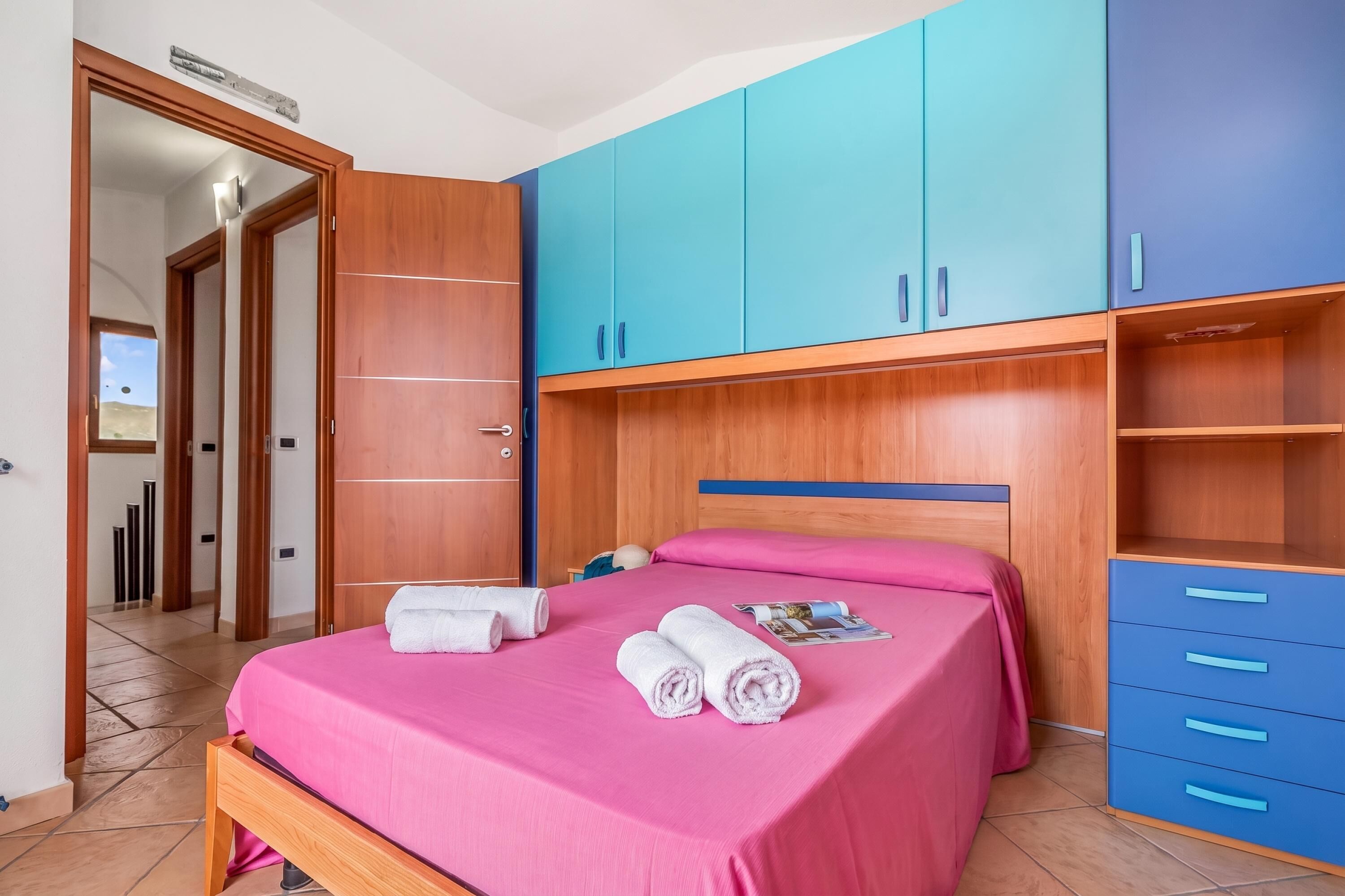 Une chambre à coucher avec un lit, une armoire en bois et un meuble bleu.