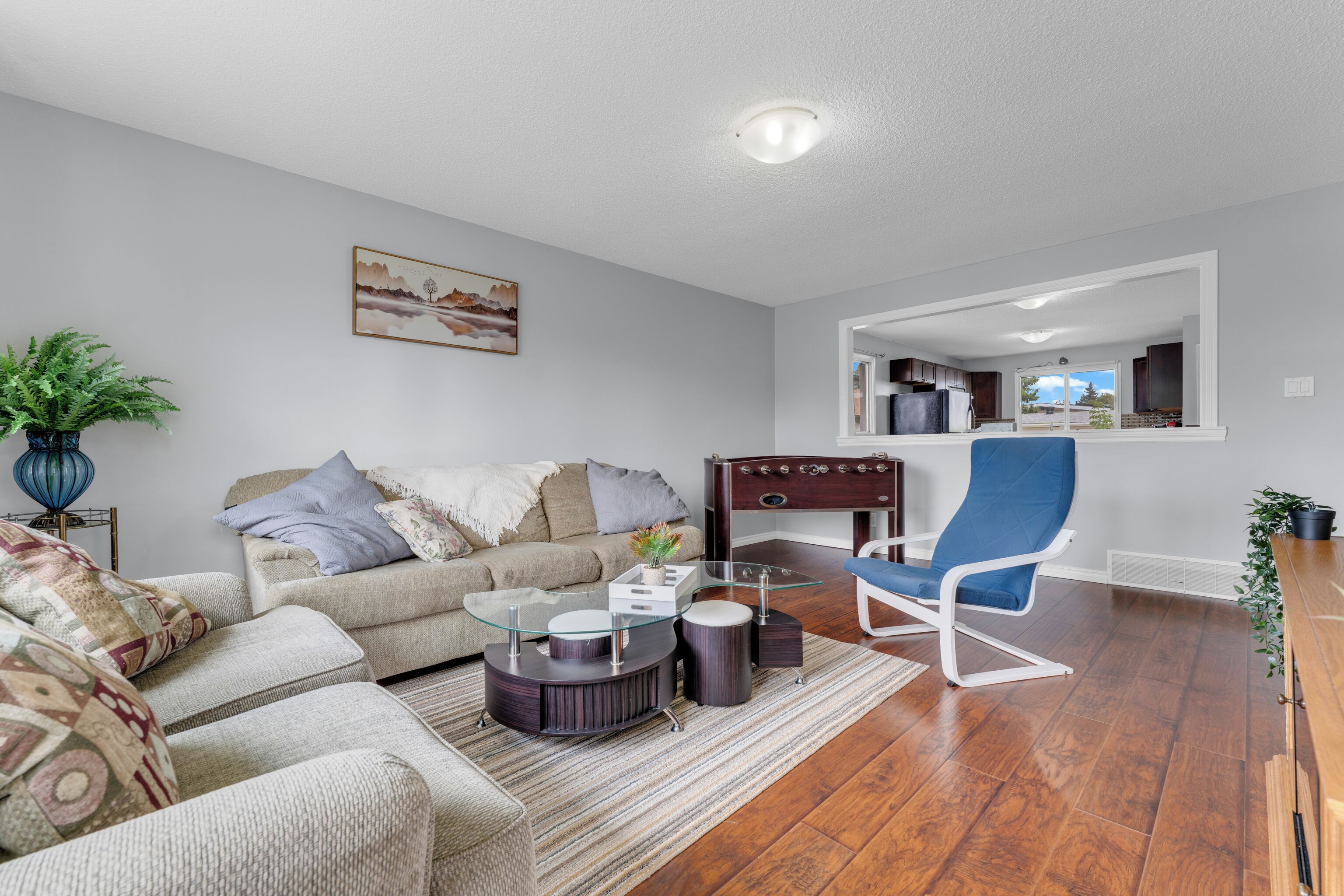 A modern living room with a sofa, coffee table, and a blue chair.