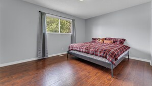 Un dormitorio con una cama individual, una ventana con cortinas y una lámpara en el techo.
