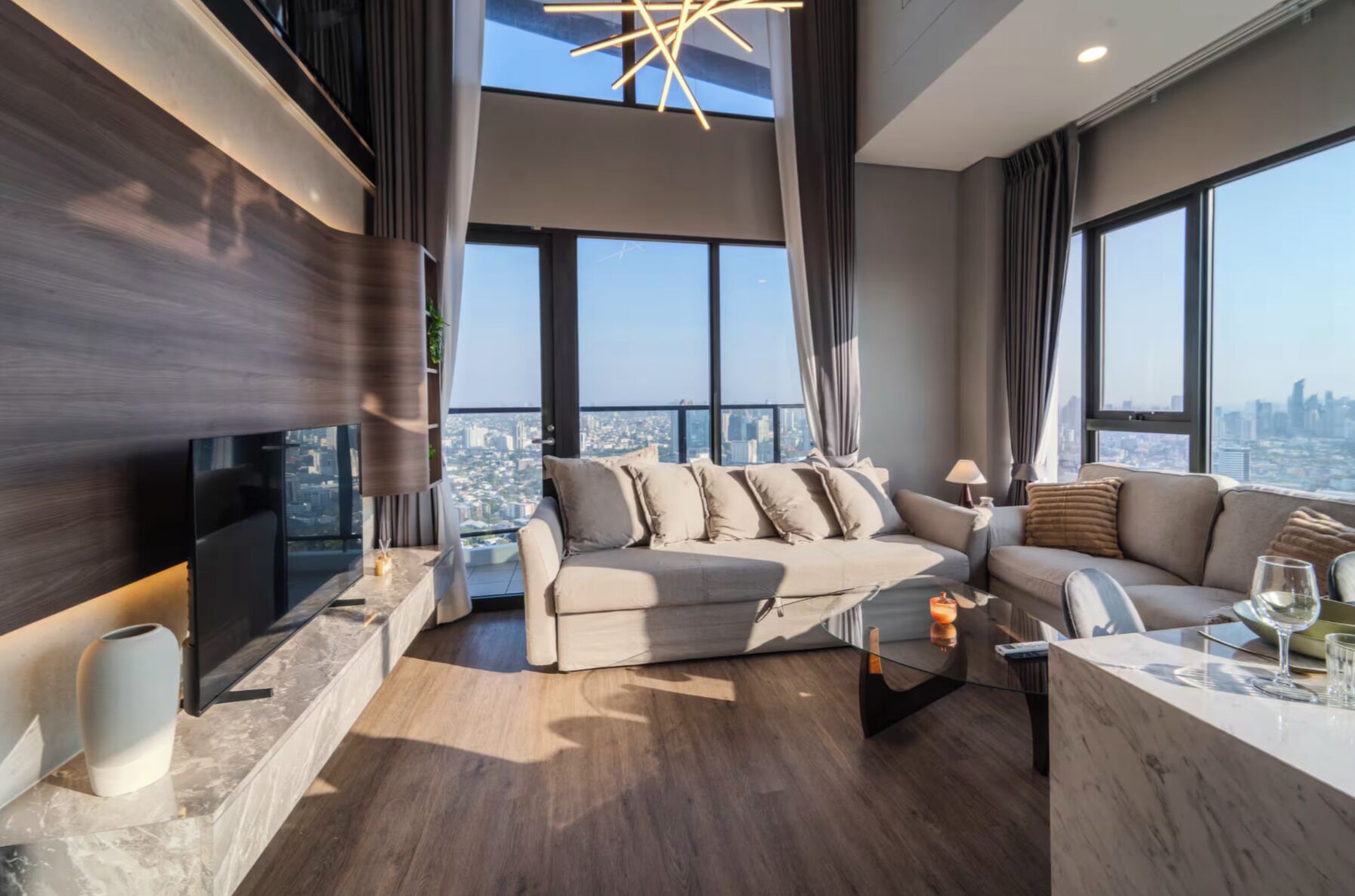 A modern living room with a sofa set, a coffee table, and a TV.