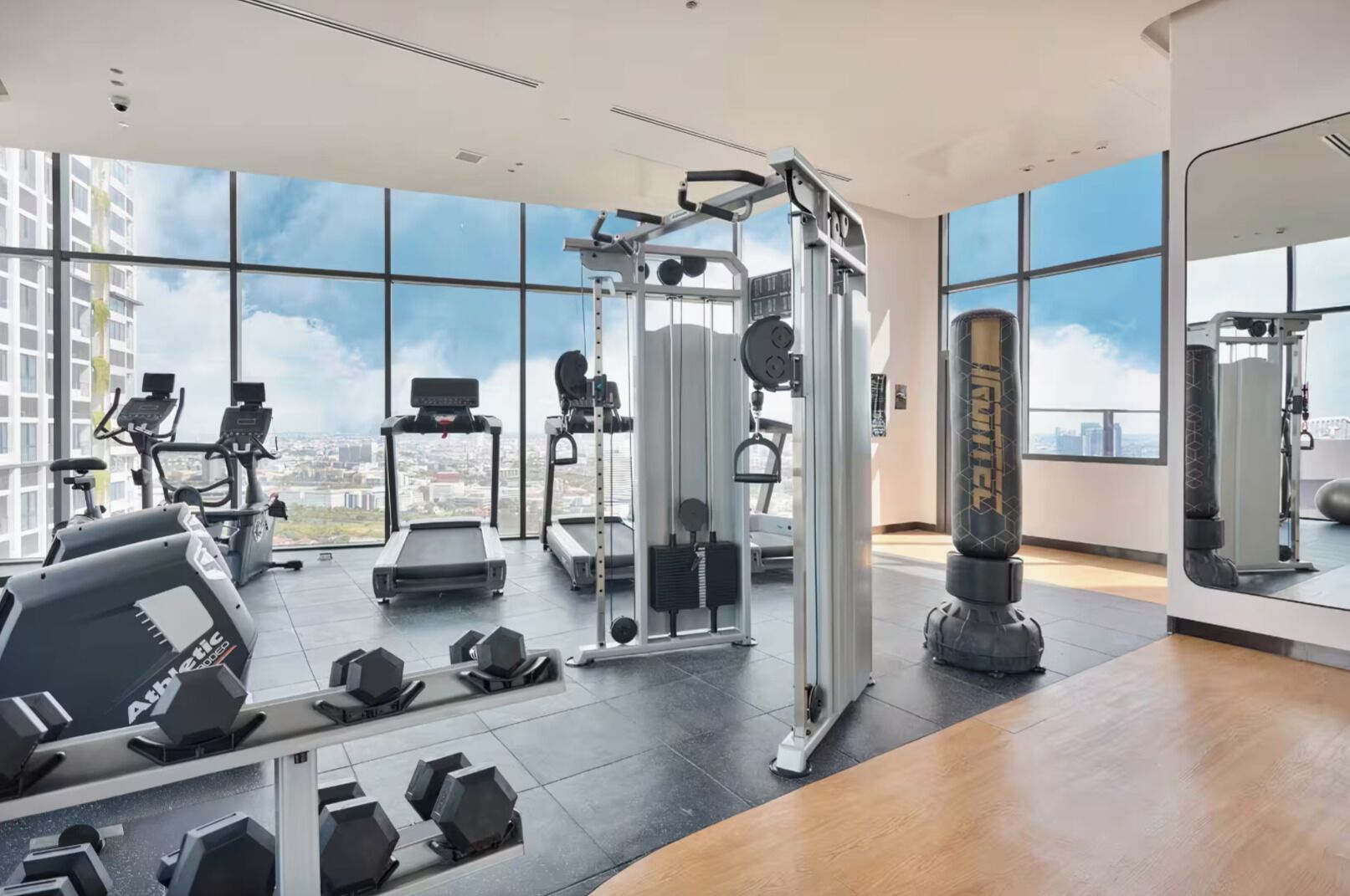 A gym with cardio machines, free weights, and a squat rack.