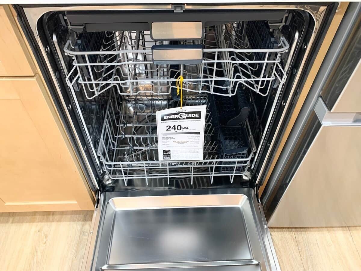 Een open vaatwasser met een label dat een energieverbruik van 240 kWh aangeeft.