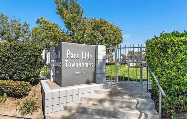 En lukket indgang til Park Lido Townhomes med et skilt, der angiver, at det er privat område.