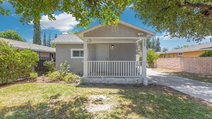 A single-story house with a front porch, a small attached garage, and a well-maintained lawn. - Cozy Blue Cottage Near Old Town Monrovia, City of Hope. Pet-Friendly (Monrovia)