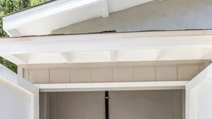 A laundry room with two white washing machines and a dryer, enclosed by a white exterior wall and a sloped roof. - Cozy Blue Cottage Near Old Town Monrovia, City of Hope. Pet-Friendly (Monrovia)