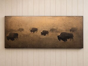 A wall-mounted artwork depicting bison in a field. - Cozy 1-bedroom studio/loft in peaceful Mansfield with AC mins from downtown (Mansfield)
