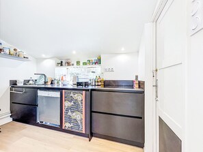 A modern kitchen with stainless steel appliances, a built-in oven, and a refrigerator. - Maison du Port by Interhome (Le Bono)