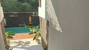 A staircase leading to a pool area with a view of a garden and a pool. - ModernBlair Vacation Rentals (Tulum)