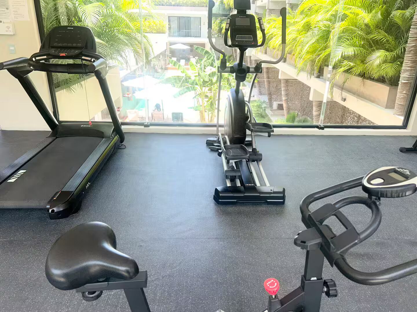 Ein Fitnessraum mit Laufband, Crosstrainer und Ergometer.