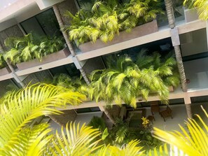 Ein mehrgeschossiges Atrium mit üppigen Grünpflanzen und modernem architektonischen Design.