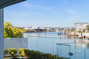 Vista sull'acqua con edifici, un molo e cielo sereno.