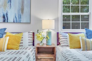 A bedroom with two beds, a nightstand with a lamp, and a window with a view of greenery. - Modern Monrovia Retreat By Old Town & City of Hope - Free Parking - Pet-Friendly (Monrovia)