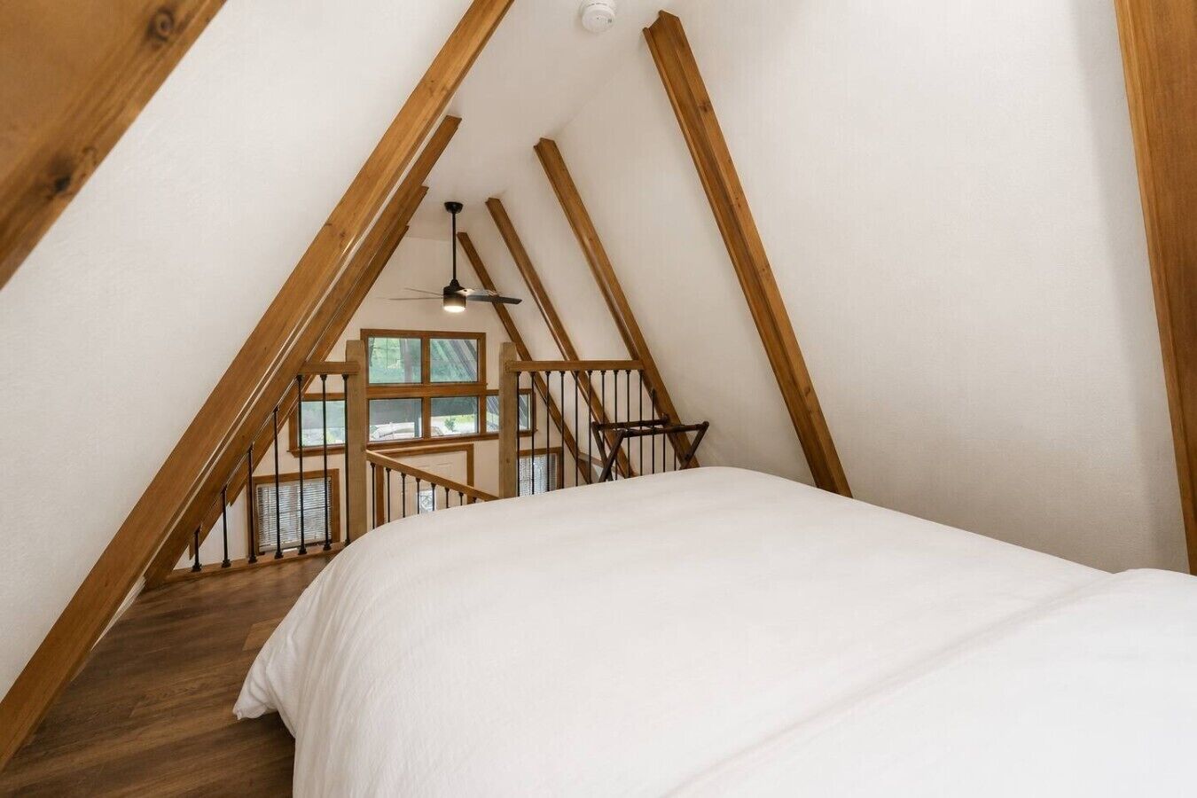 Une chambre avec un escalier en bois menant à une mezzanine.