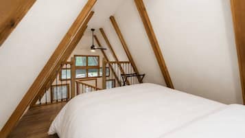 Une chambre avec un escalier en bois menant à une mezzanine.