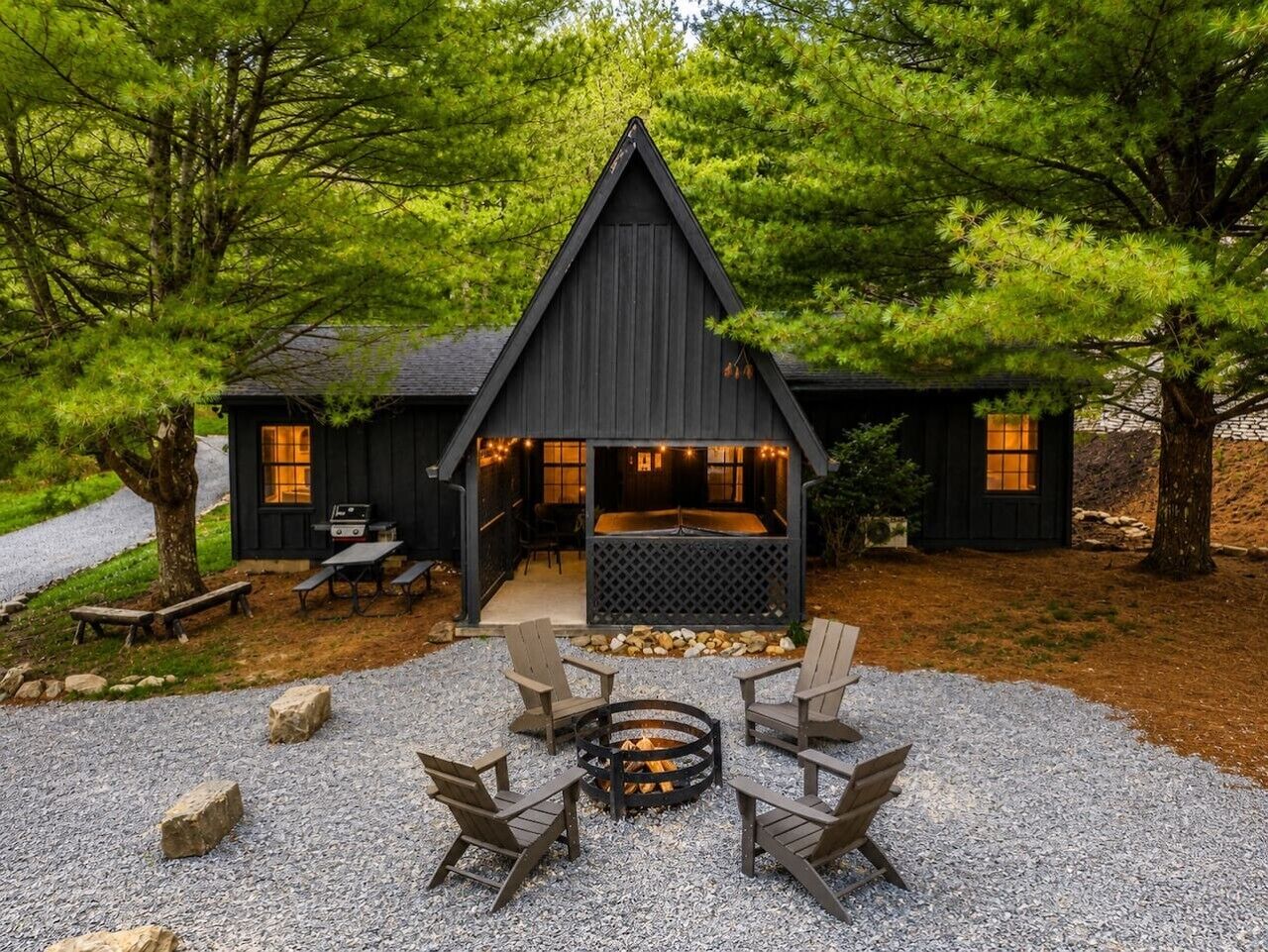 Eine Hütte mit Kamin, Sitzgelegenheiten im Freien und einer Kiesterrasse.
