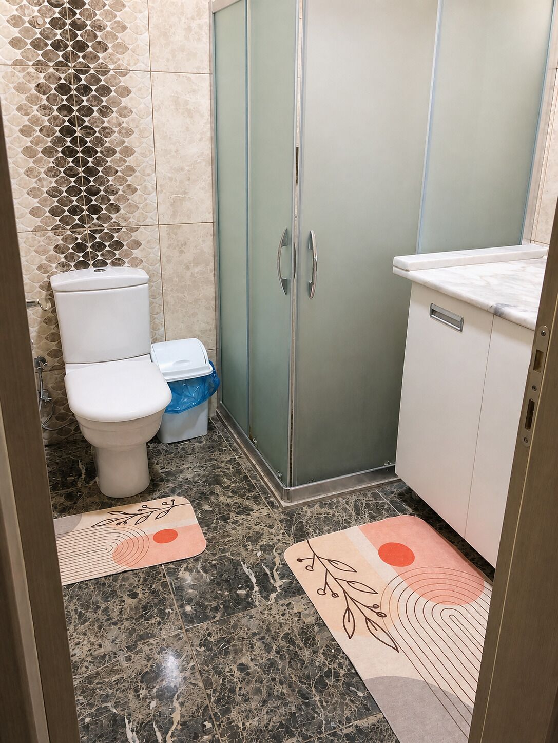 Ein Badezimmer mit Toilette, einem Schrank und einer Duschkabine.