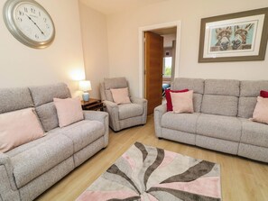 A living room with two sofas, a chair, a rug, a clock, and a framed picture on the wall. - BIDDY GRANNY'S, pet friendly in Annagry, County Donegal (County Donegal)