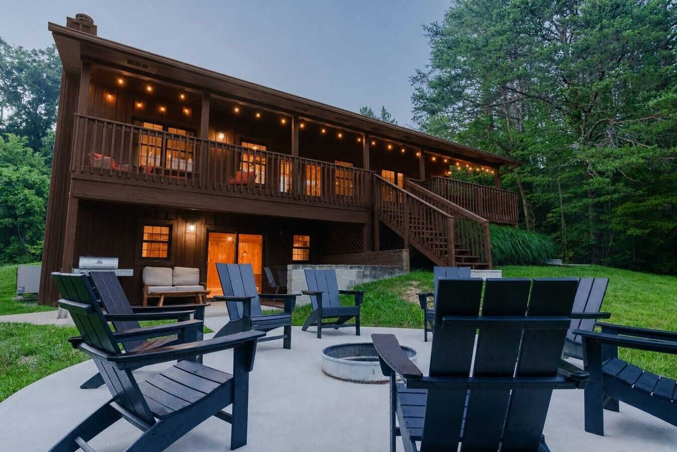 A two-story wooden building with a balcony, outdoor seating area, and a staircase leading to the upper level.