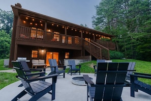 A two-story wooden building with a balcony, outdoor seating area, and a staircase leading to the upper level. - Houston Lodge: HotTub, GameRoom, Pets, BBQ, Trails (Logan)