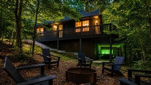 Une cabane dotée d’une terrasse, d’un espace salon extérieur et d’un foyer.