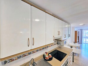 Eine moderne Küche mit weißen Schränken, einer schwarzen Arbeitsplatte und einer Mikrowelle.