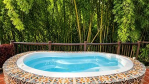 Un bain à remous entouré de carreaux décoratifs, le tout mis en valeur par un décor de bambous.