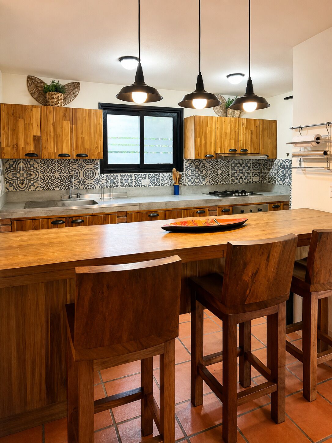 A kitchen with wooden cabinets, a large island with bar stools, and pendant lighting.