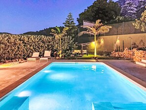 Ein Schwimmbecken mit Liegestühlen und einer Pergola.
