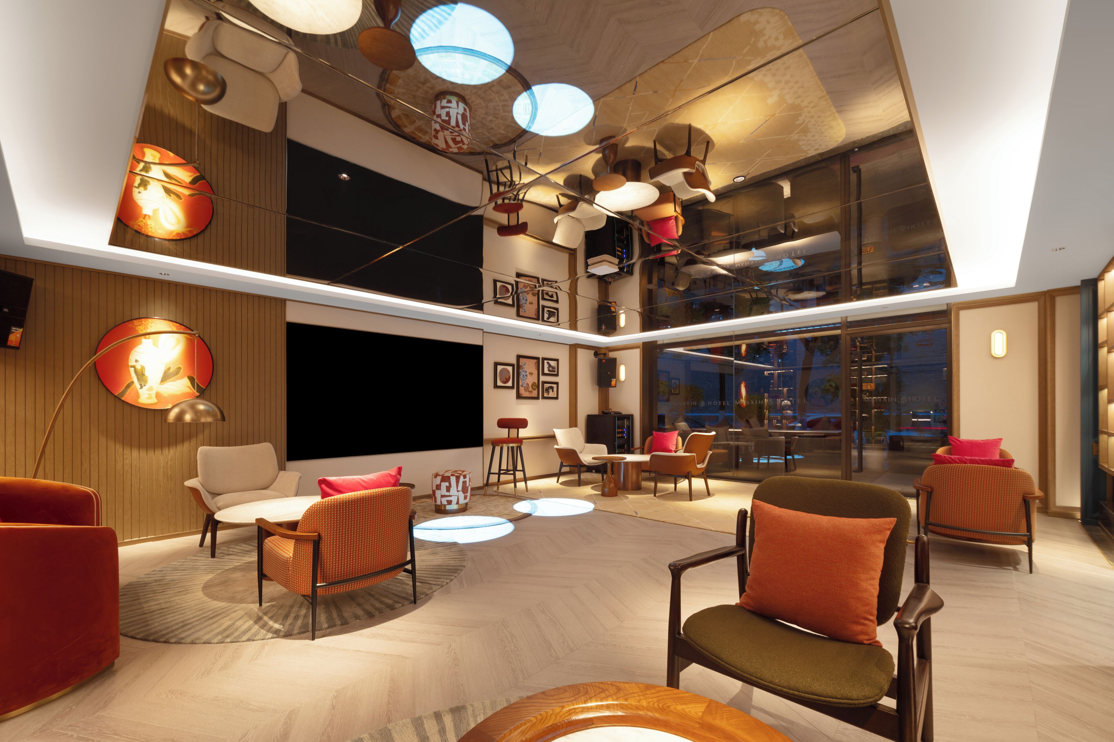 A modern hotel lobby with a high ceiling, contemporary furniture, and a large window offering a view of the cityscape.