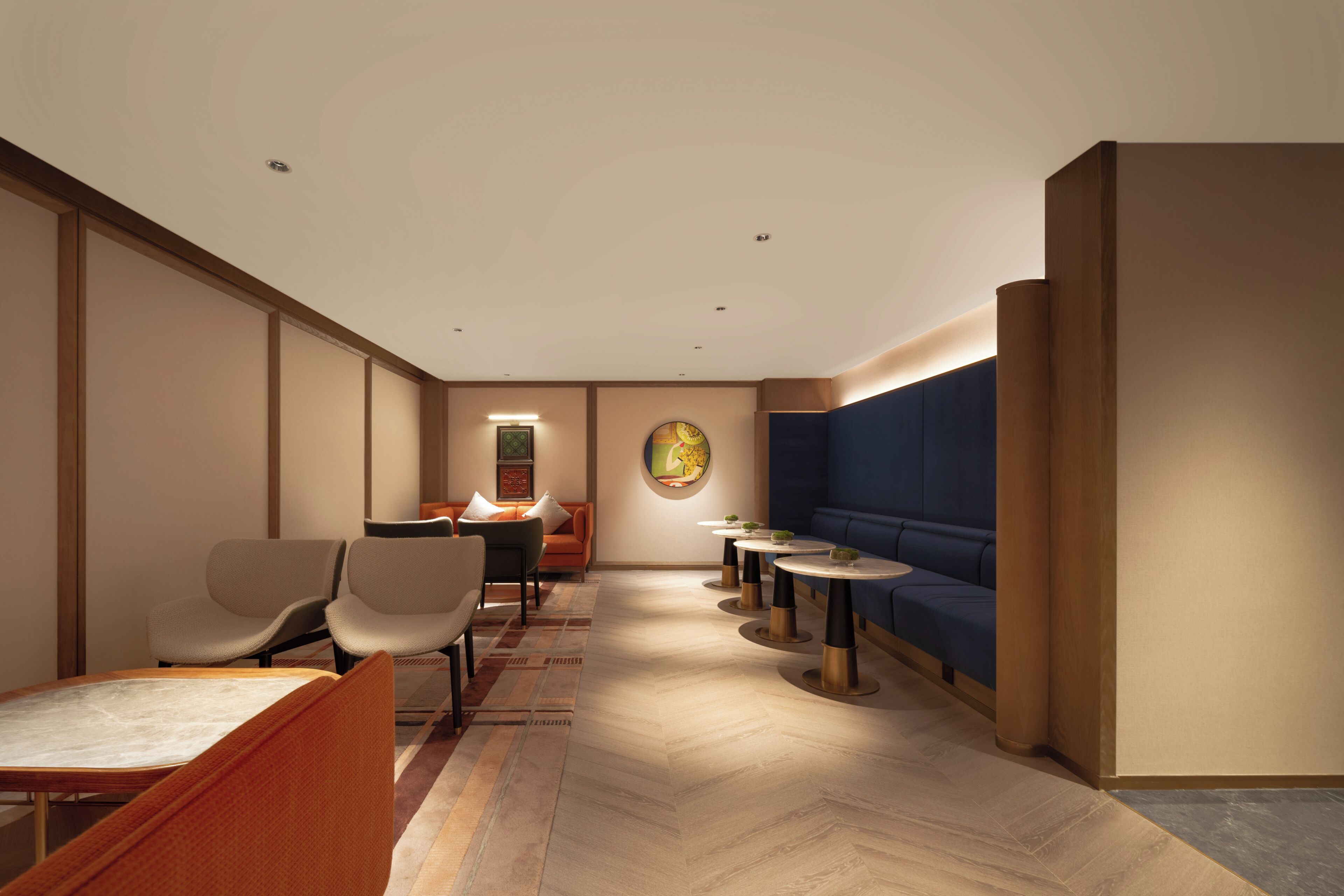 A hotel lobby with seating areas, a reception desk, and a wall-mounted artwork.