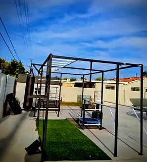 A metal structure with a roof, possibly a gym or play area, in a backyard with a lawn and a building in the background. - Resort-Style Private suite #2 Near PHX with Pool/Gym (Phoenix)