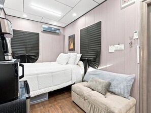 A bedroom with a bed, a sofa, a desk with a computer, and an air conditioning unit. - Resort-Style Private suite #2 Near PHX with Pool/Gym (Phoenix)