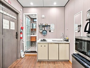 A modern kitchen with a built-in oven, a sink, and a stove. There is a fire extinguisher mounted on the wall and a sign indicating a shared kitchen area. - Resort-Style Private suite #2 Near PHX with Pool/Gym (Phoenix)