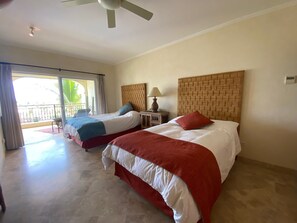 A hotel room with two beds, a balcony, and a ceiling fan. - Beachfront condo in Paradise 3 bed /2 bath (San José del Cabo)