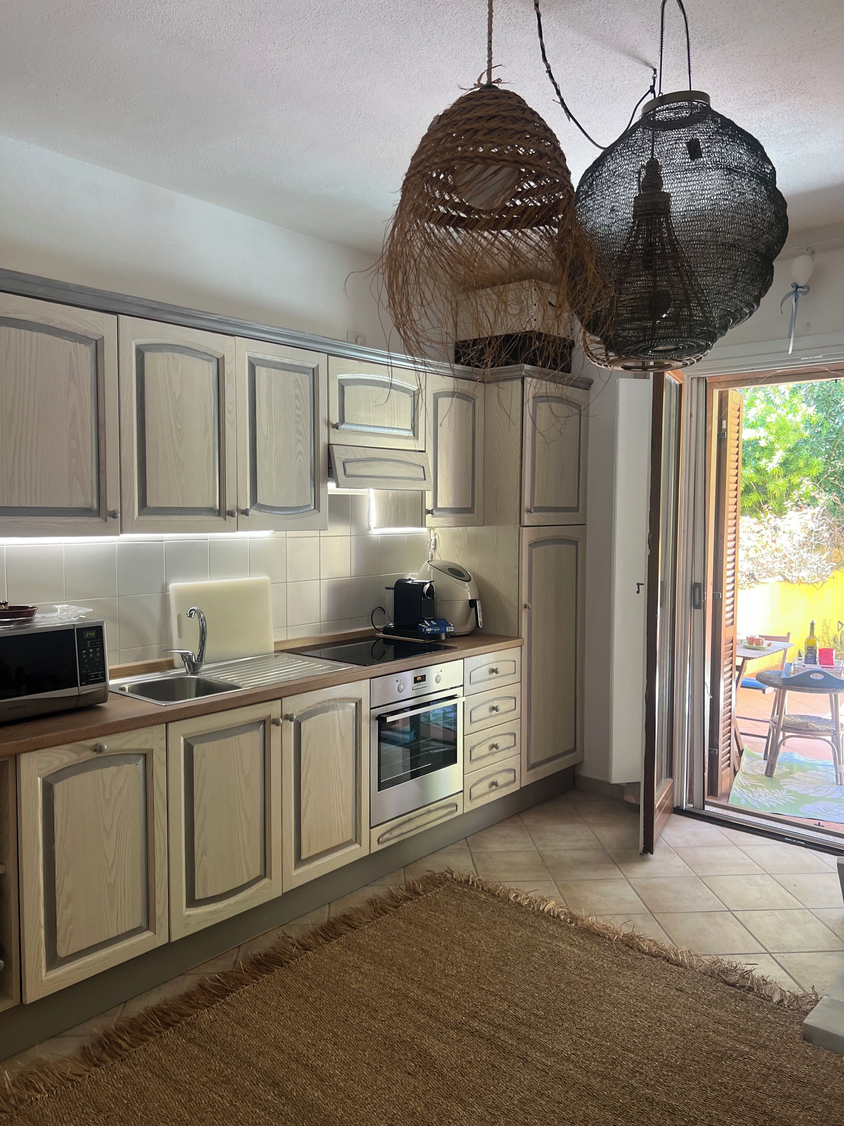 Une cuisine moderne avec des meubles en bois, un four encastré et un four à micro-ondes.