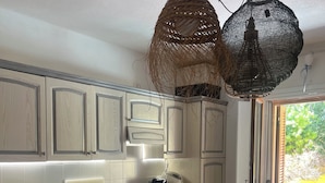 A modern kitchen with wooden cabinets, a built-in oven, and a microwave. - House with a garden in Santa Teresa di Gallura (Santa Teresa di Gallura)