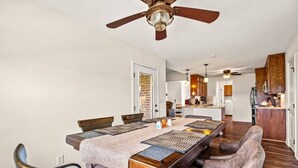 A dining area with a long table, chairs, and a ceiling fan. - Family Country Home | Gaming, Workspace, Yard (Terrell)