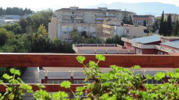 Un edificio a più piani con tetto piatto, circondato dal verde e da altri edifici.