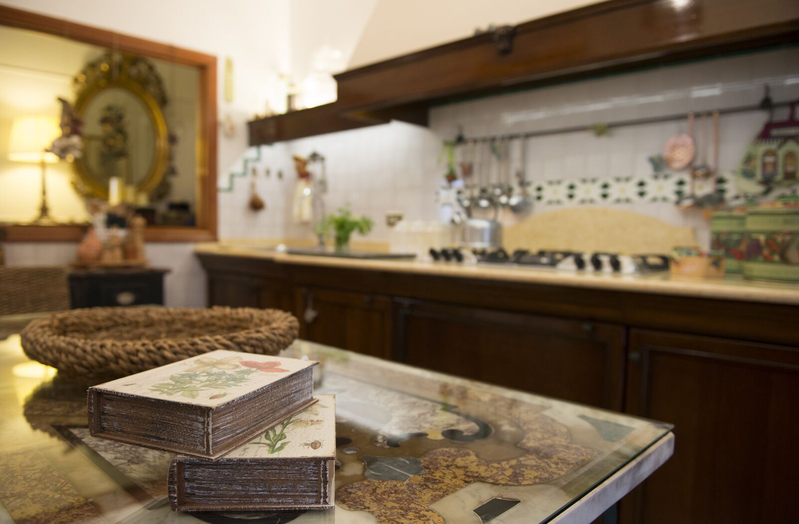 Cuina amb armaris de fusta, taulell de marbre i un respatller decoratiu.